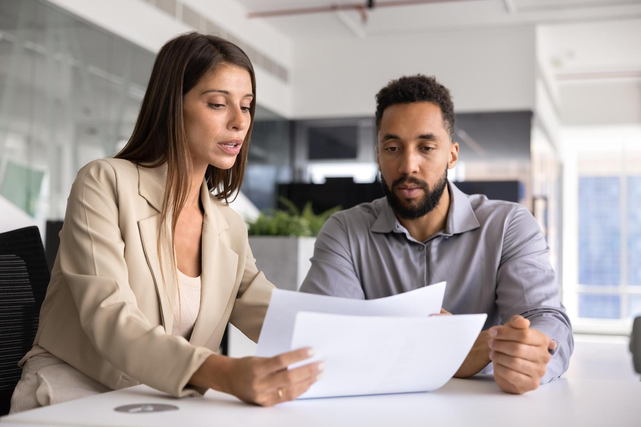 An advisor reviewing claim documents with a worker across a desk